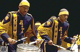 [In blue and gold with drums]