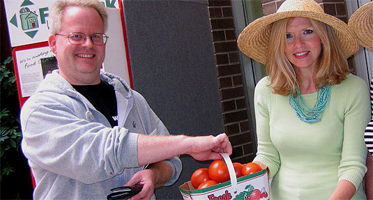 [Smiles as they hand over a basket of red tomatoes]