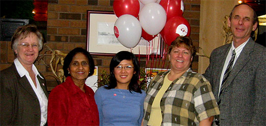 [Five people with bunch of red-and-white balloons]