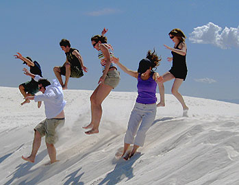 [Six of them jumping on a dune]