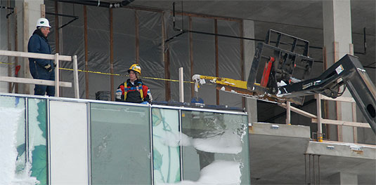 [Workers and equipment seen at an upper level]