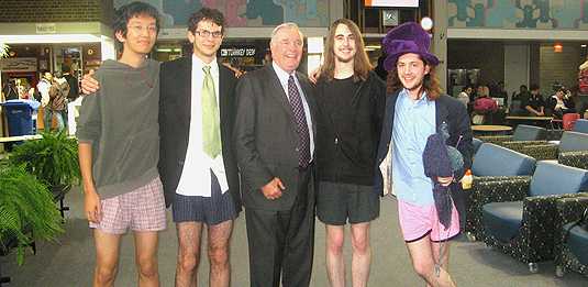[Four young men in shorts and one old man in a suit]