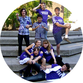 [Cast of eight, in purple shirts]