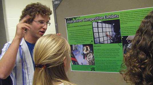 [Explaining his poster to two fellow-students]