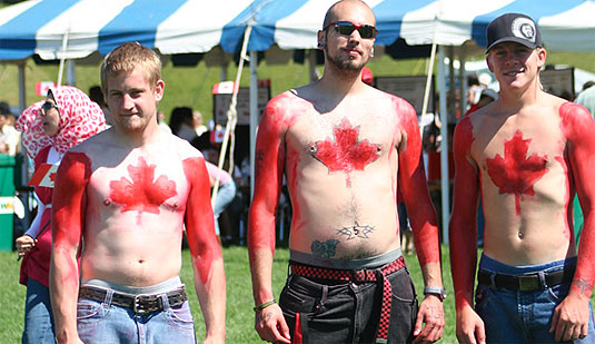 [Three guys with flags painted on their chests]