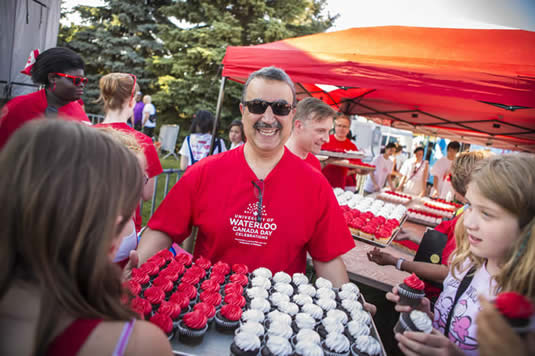 Feridun Hamdullahpur passes out cupcakes at the Canada Day event.