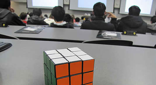 [Rubik's cube on table at back of lecture hall]