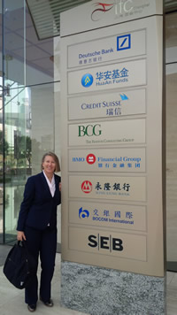 Lisa ter Woort stands next to a tall sign featuring several corporate logos.