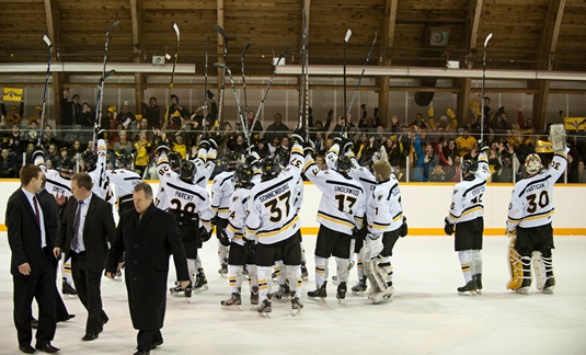 The Warrior men's hockey team raise their sticks in salute after their victory Saturday night.