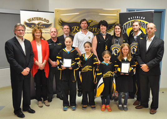 Young hockey players and representatives from the University of Waterloo and the Ravens Girls Minor Hockey program.