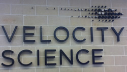 Velocity Science sign mounted on the wall of the lab.