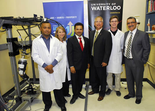 Graduate students, researchers, and government officials pose with the knee injury simulator.