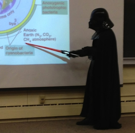 Darth Neufeld instructs his students, using a lightsaber as a pointer.