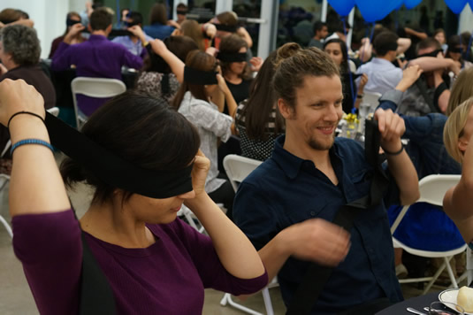 Participants place blindfolds on during the Dining in the Dark event.