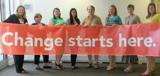 Members of the United Way University of Waterloo campaign pose with a banner that reads "Change Starts Here."