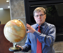 Larry smith holding a globe.